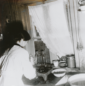 876918 Afbeelding van een Zuster Augustines (in opleiding?) die als gezinshulp werkt bij een gezin, vermoedelijk in ...